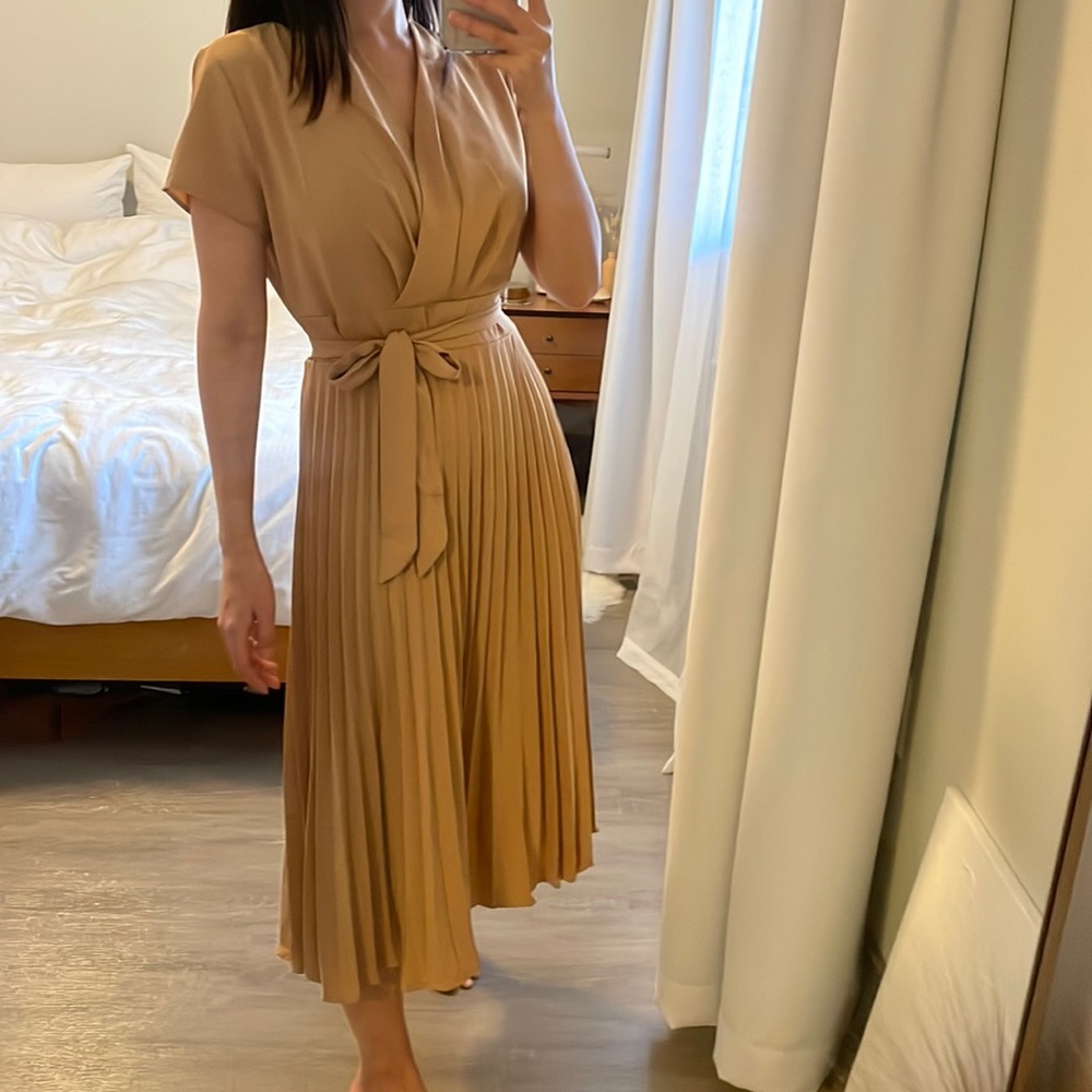 Beige dress with wrap top detail, pleated skirt, and tied waist